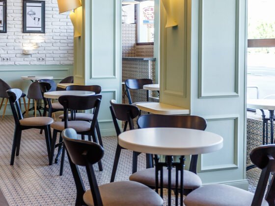 Sage green cafe interior, black and white tables and chairs